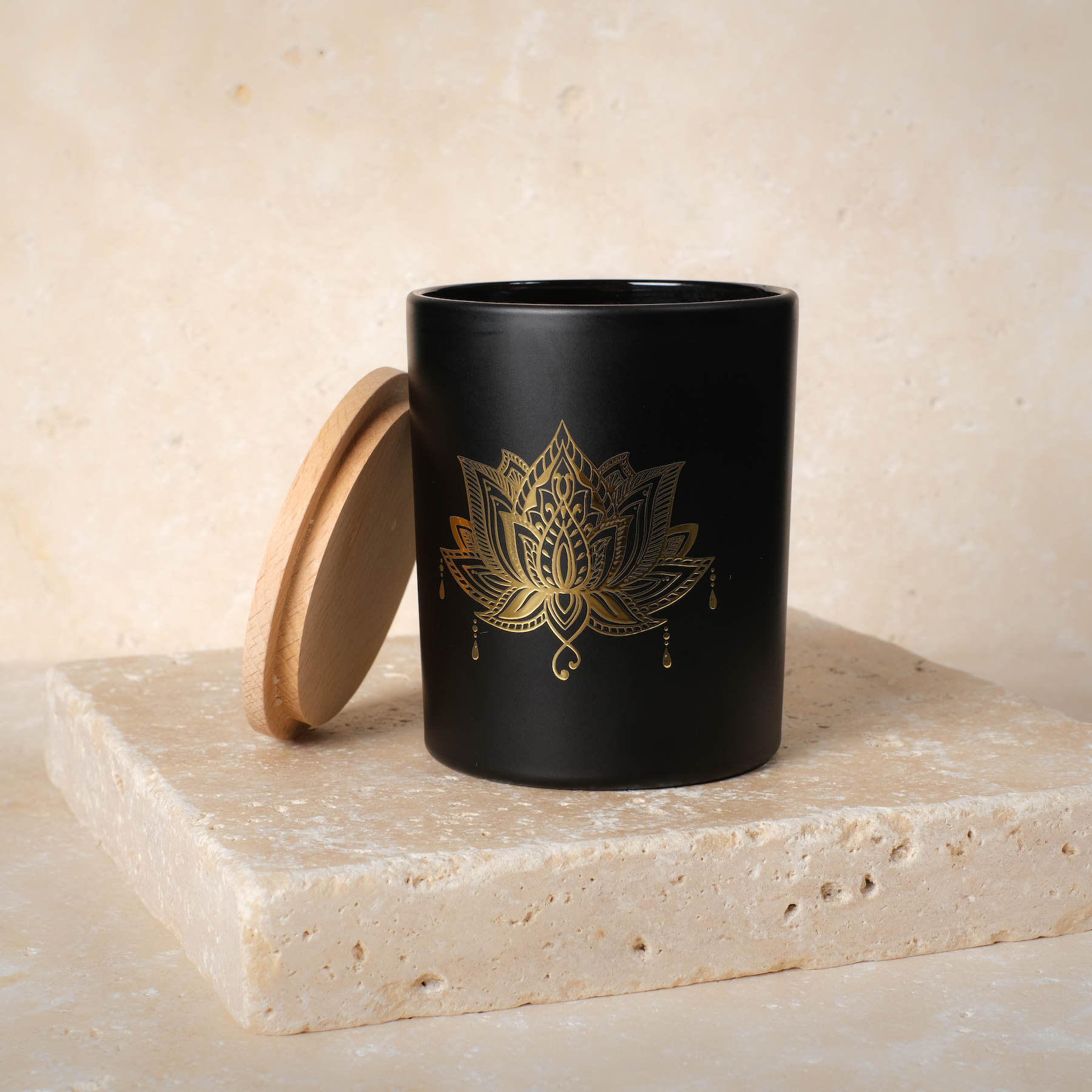 Bougie parfumée dans un verre noir avec pierres précieuses