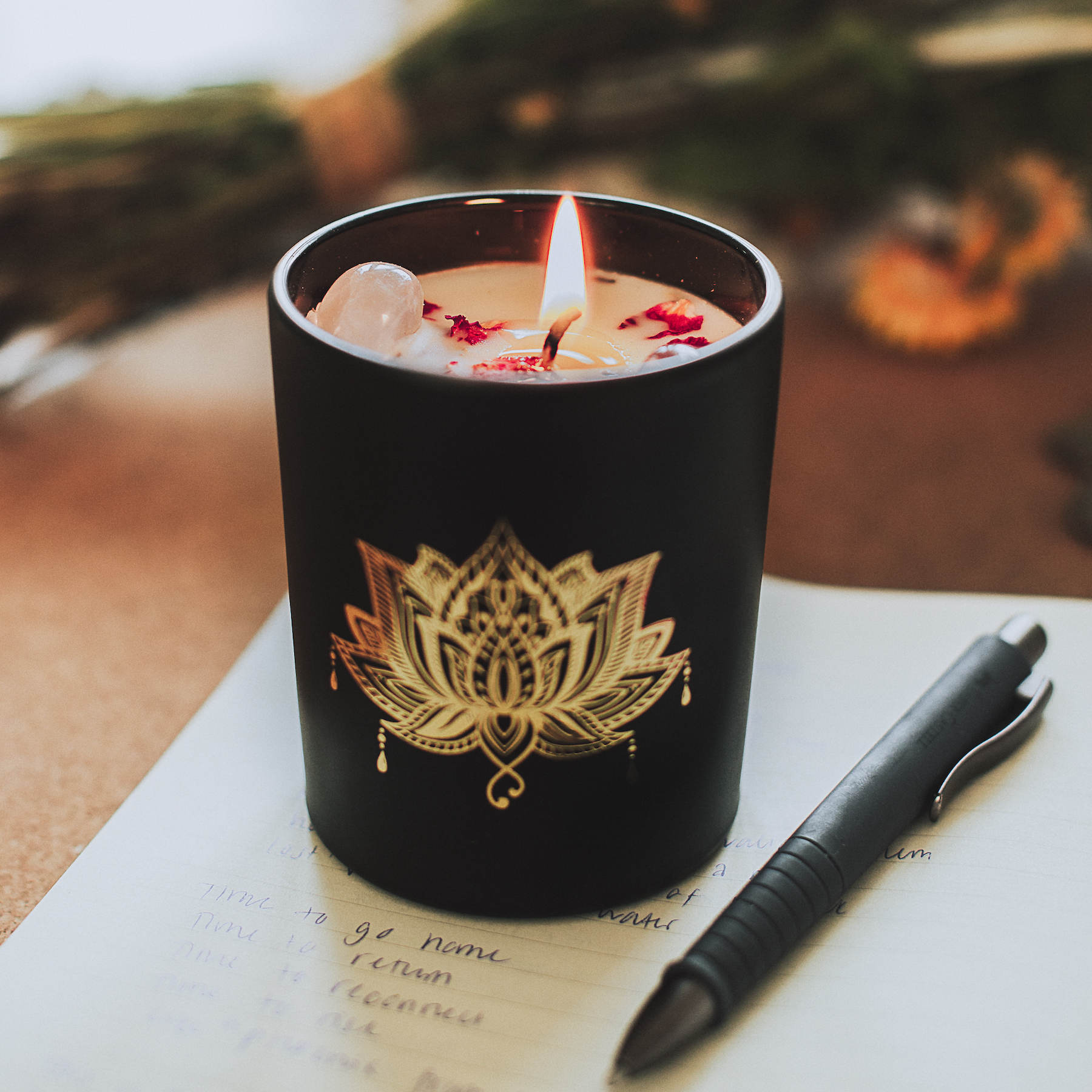 Bougie parfumée dans un verre noir avec pierres précieuses